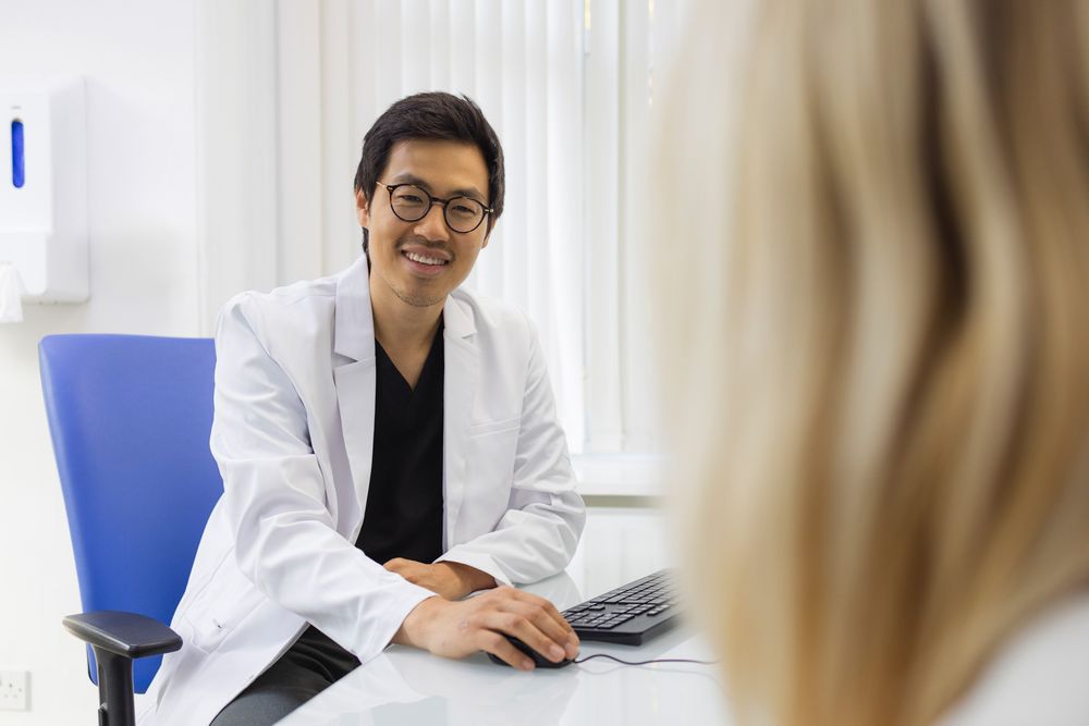 Healthcare provider consulting with patient in medical office setting.