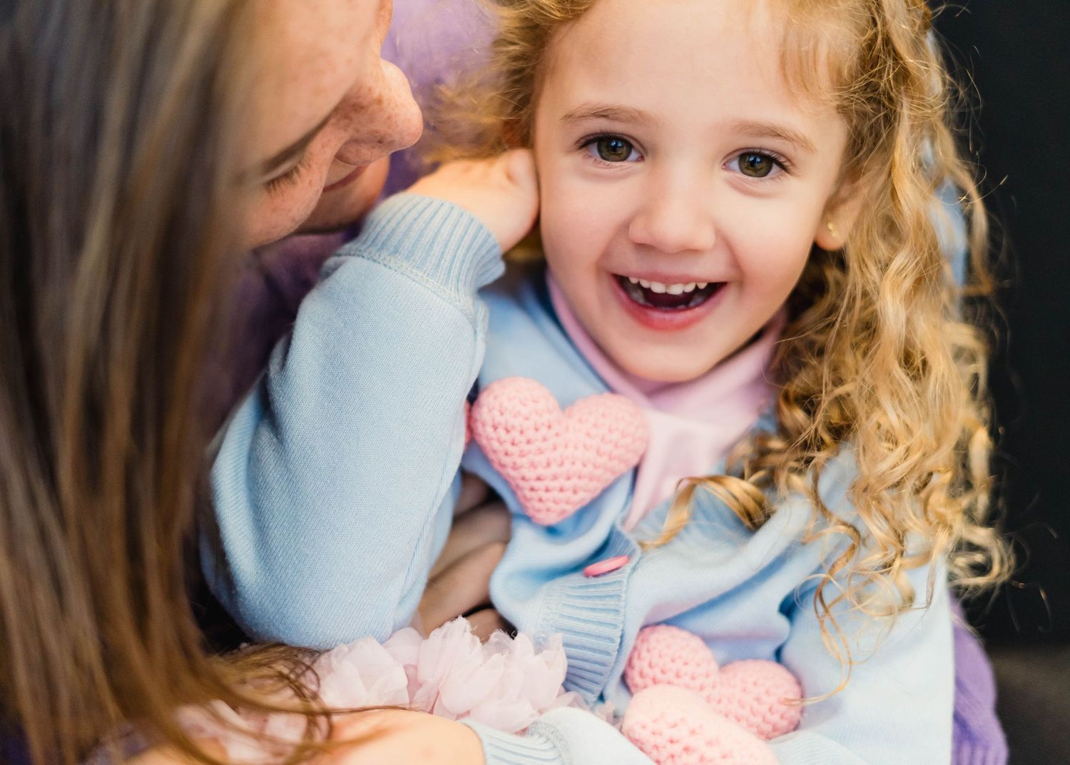Mom and daughter snuggling and laughing at a school photo session at melbourne kids village