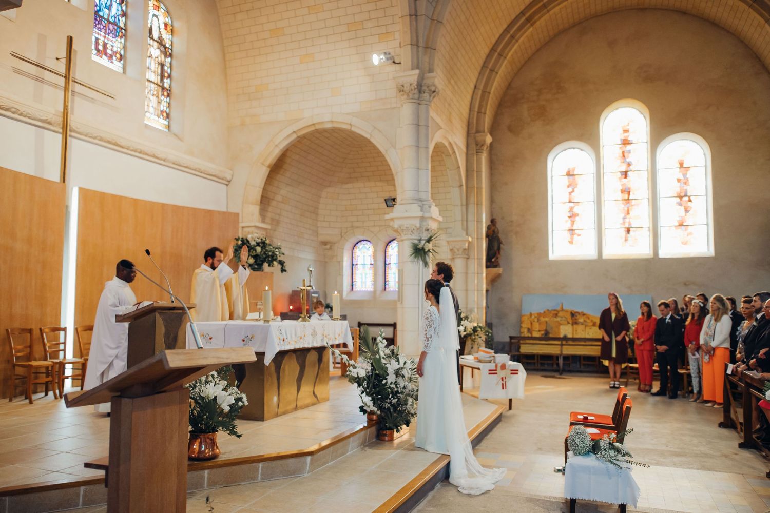 Bride and groom exchanging vows at a beautiful stone church wedding ceremony with guests.