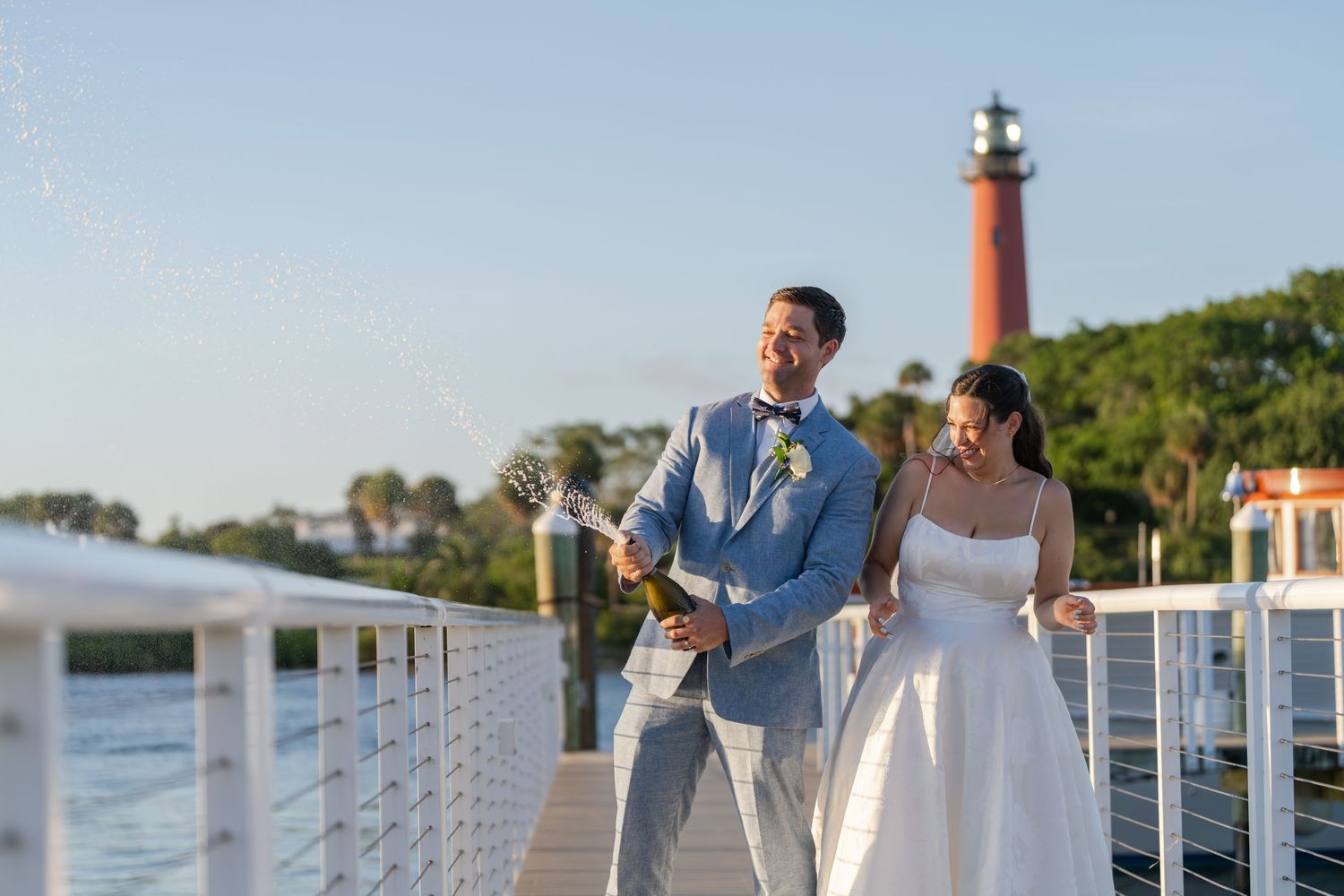 A couple exits through rustic wooden doors at an outdoor wedding ceremony with a written quote overhead.
