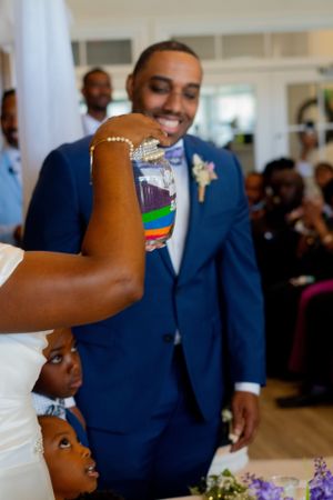 A playful wedding reception moment with guests interacting in a bright indoor setting.