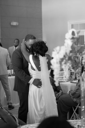 A tender moment between newlyweds during their wedding reception in black and white.