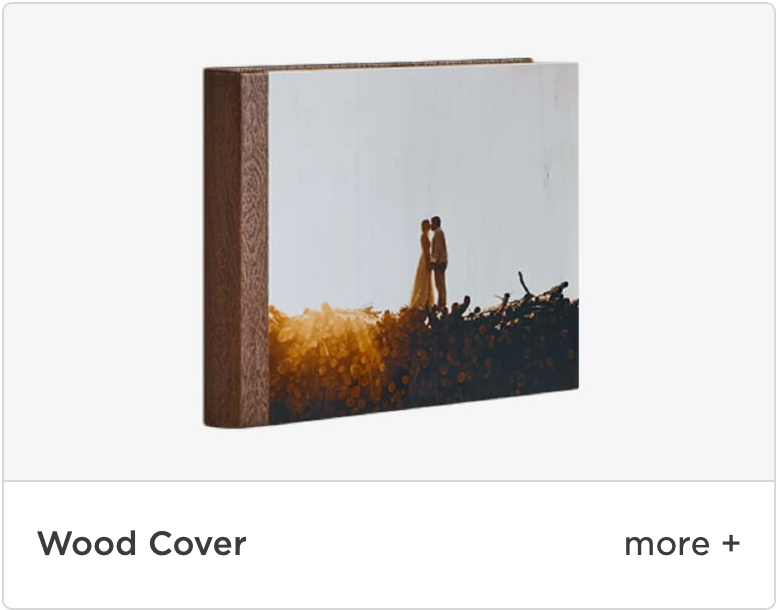 A wood cover photo album displays a silhouetted couple against a golden sunset background.