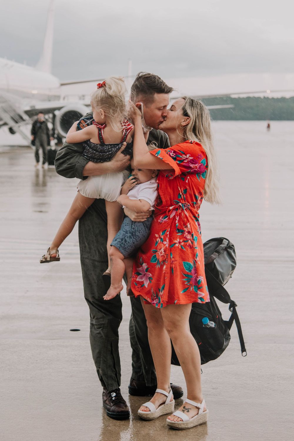 A military family embraces at a deployment homecoming on the flight line in Jacksonville, Florida.