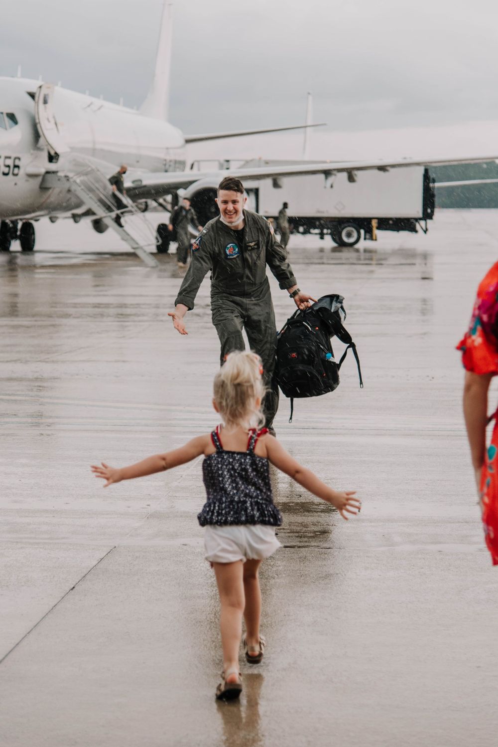 A military family embraces at a deployment homecoming on the flight line in Jacksonville, Florida.