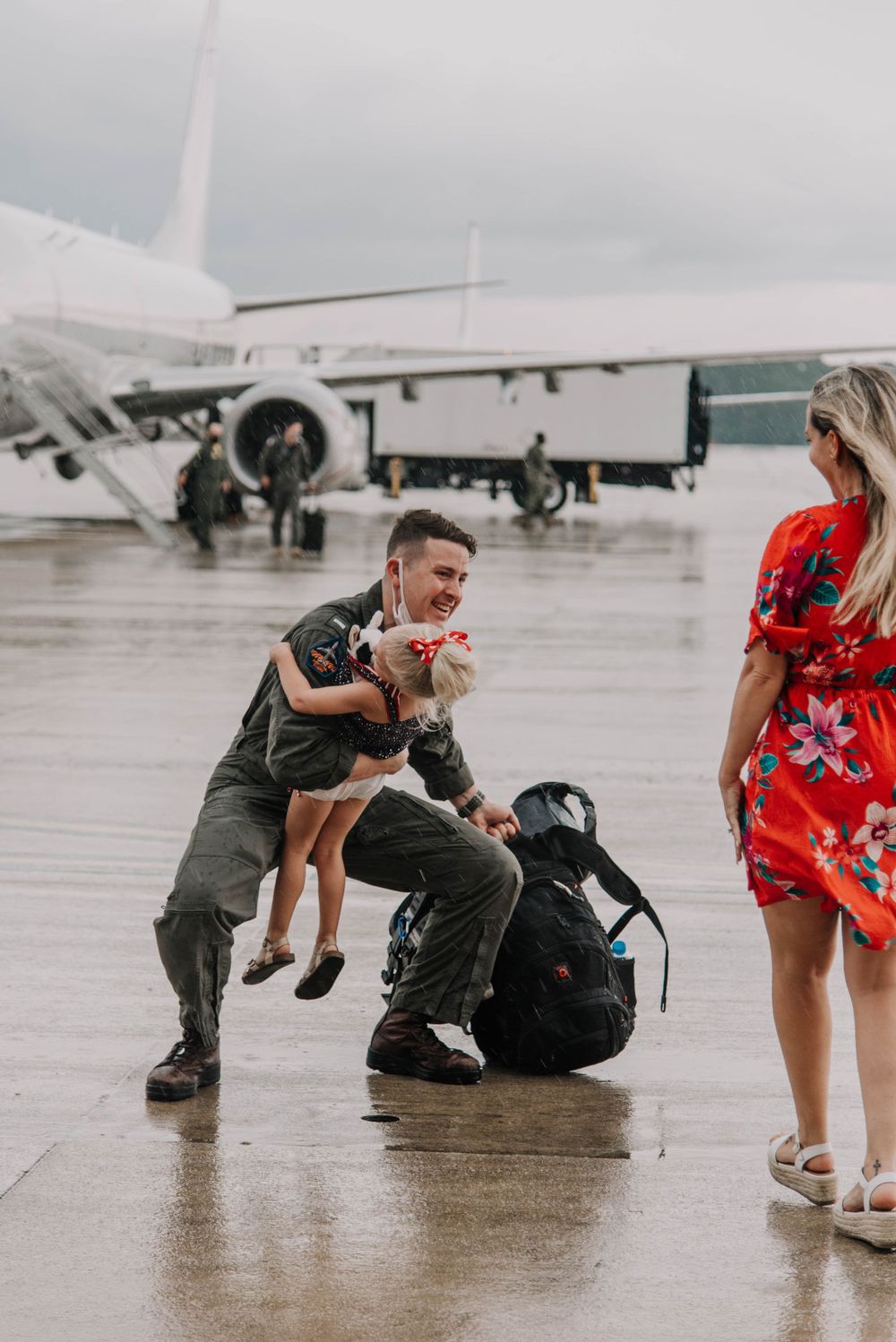 A military family embraces at a deployment homecoming on the flight line in Jacksonville, Florida.