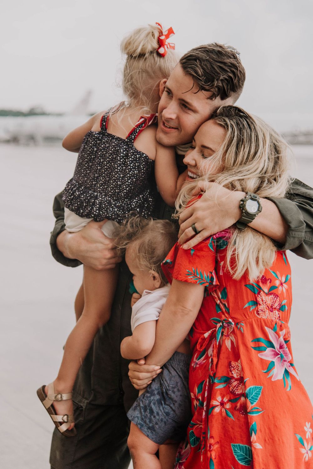 A military family embraces at a deployment homecoming on the flight line in Jacksonville, Florida.