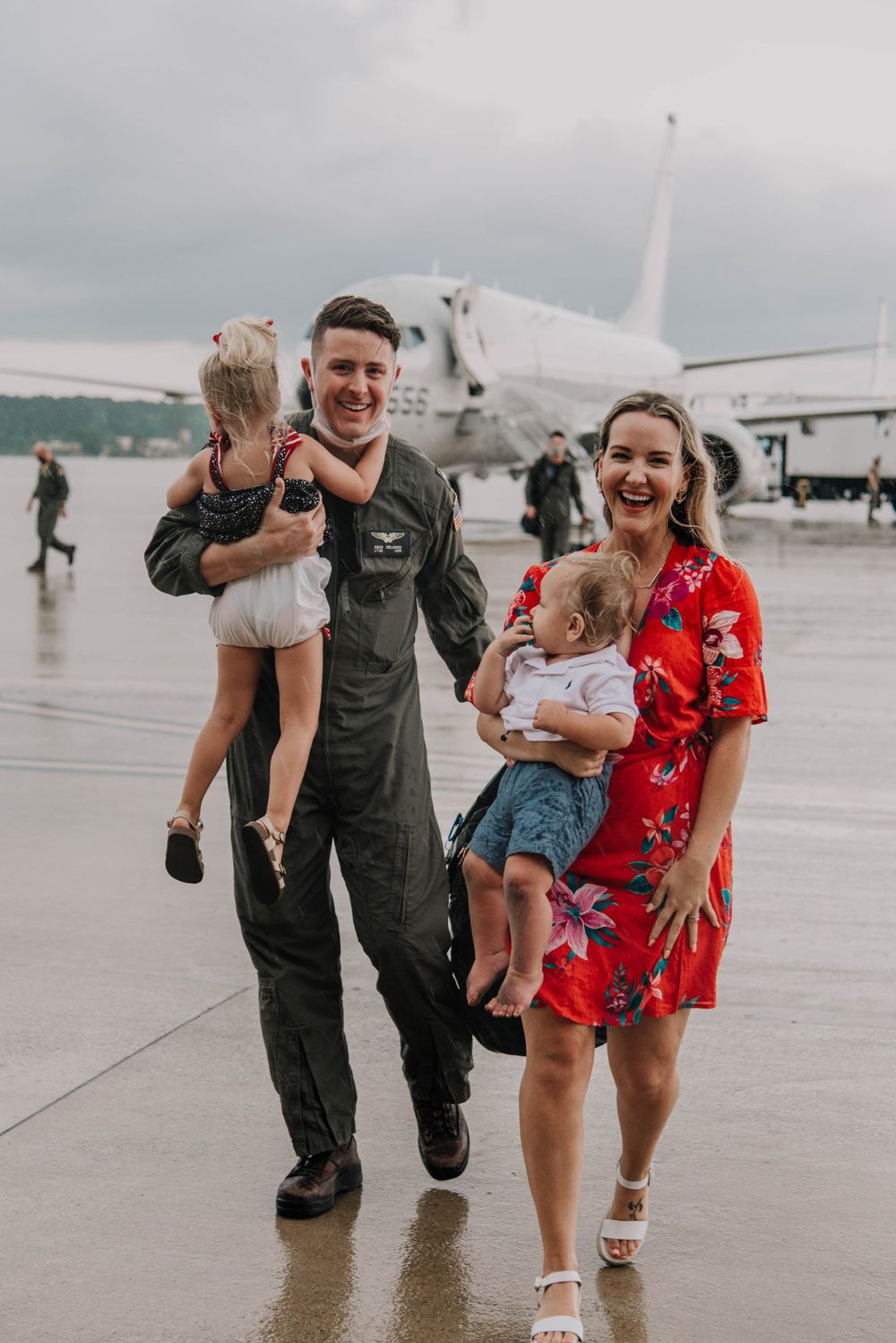 A military family embraces at a deployment homecoming on the flight line in Jacksonville, Florida.