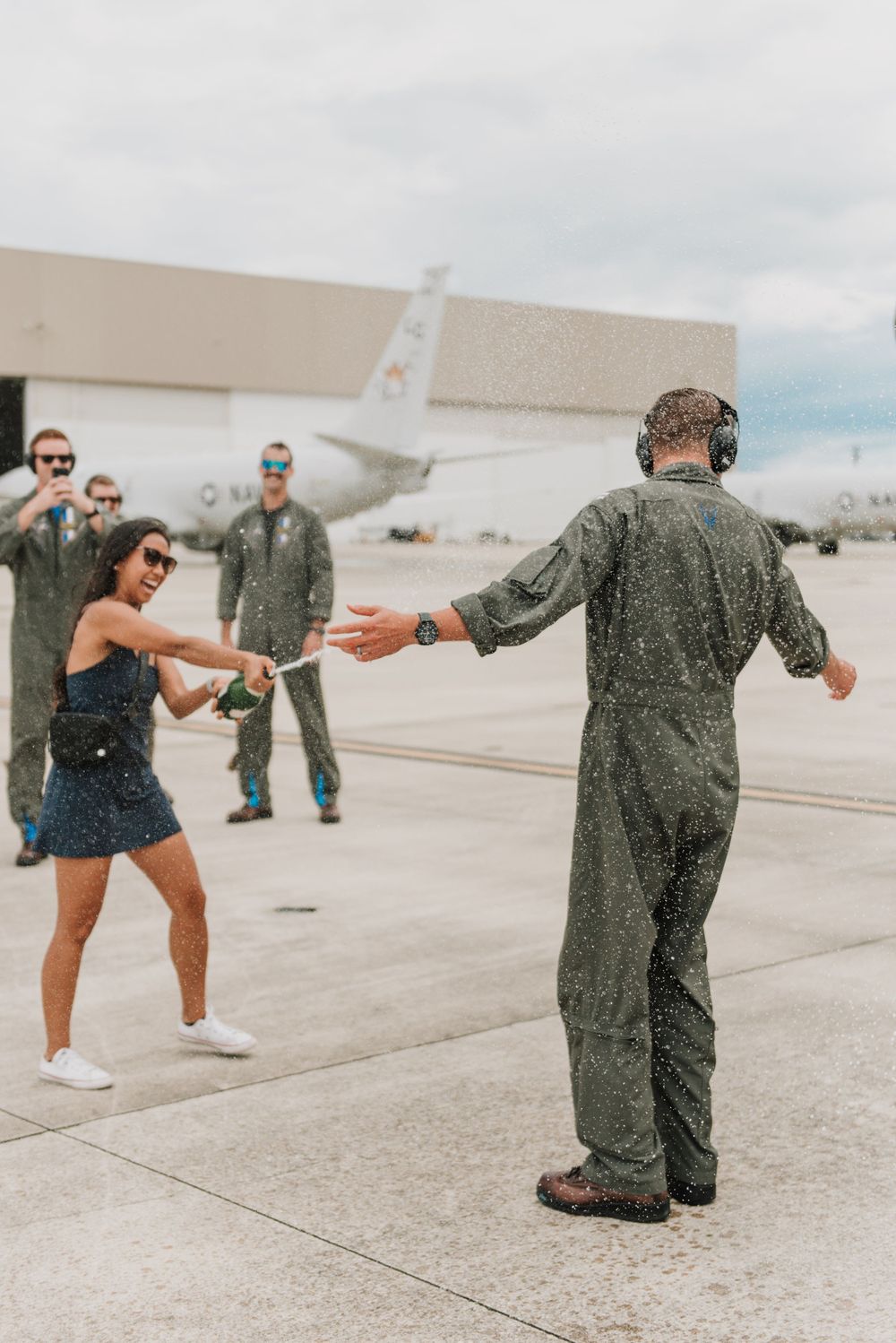 A military member enjoy a champagne shower after his final flight on the P8 Poseidon in Jacksonville, Florida.