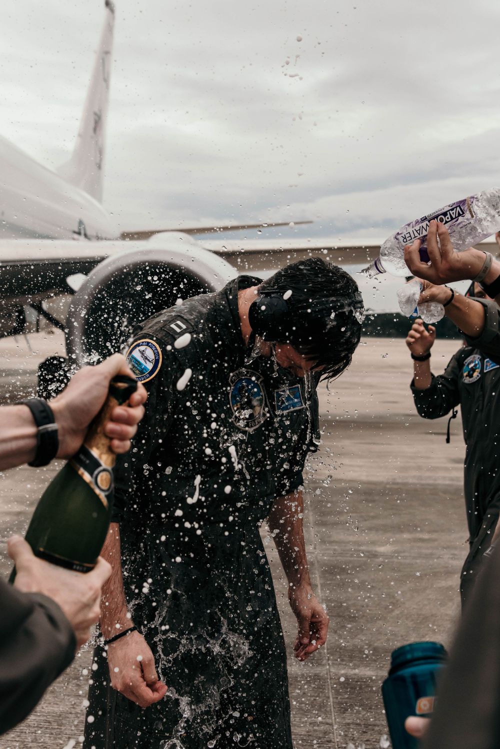 A military member enjoy a champagne shower after his final flight on the P8 Poseidon in Jacksonville, Florida.