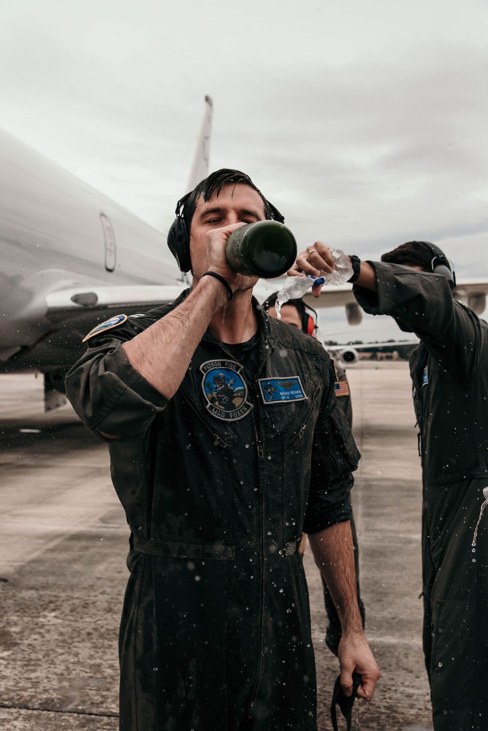 A military member enjoy a champagne shower after his final flight on the P8 Poseidon in Jacksonville, Florida.