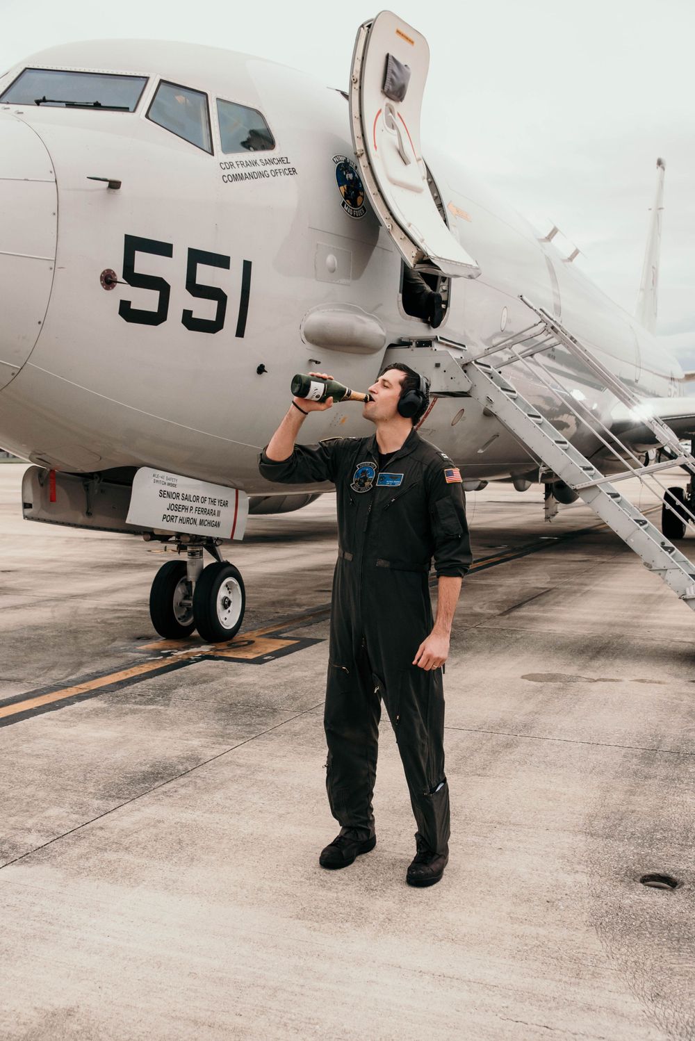 A military member enjoy a champagne shower after his final flight on the P8 Poseidon in Jacksonville, Florida.
