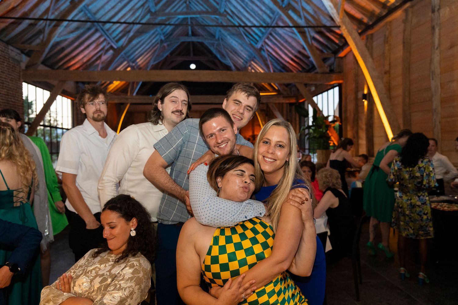Evening celebration inside rustic barn venue with warm lighting and festive atmosphere.
