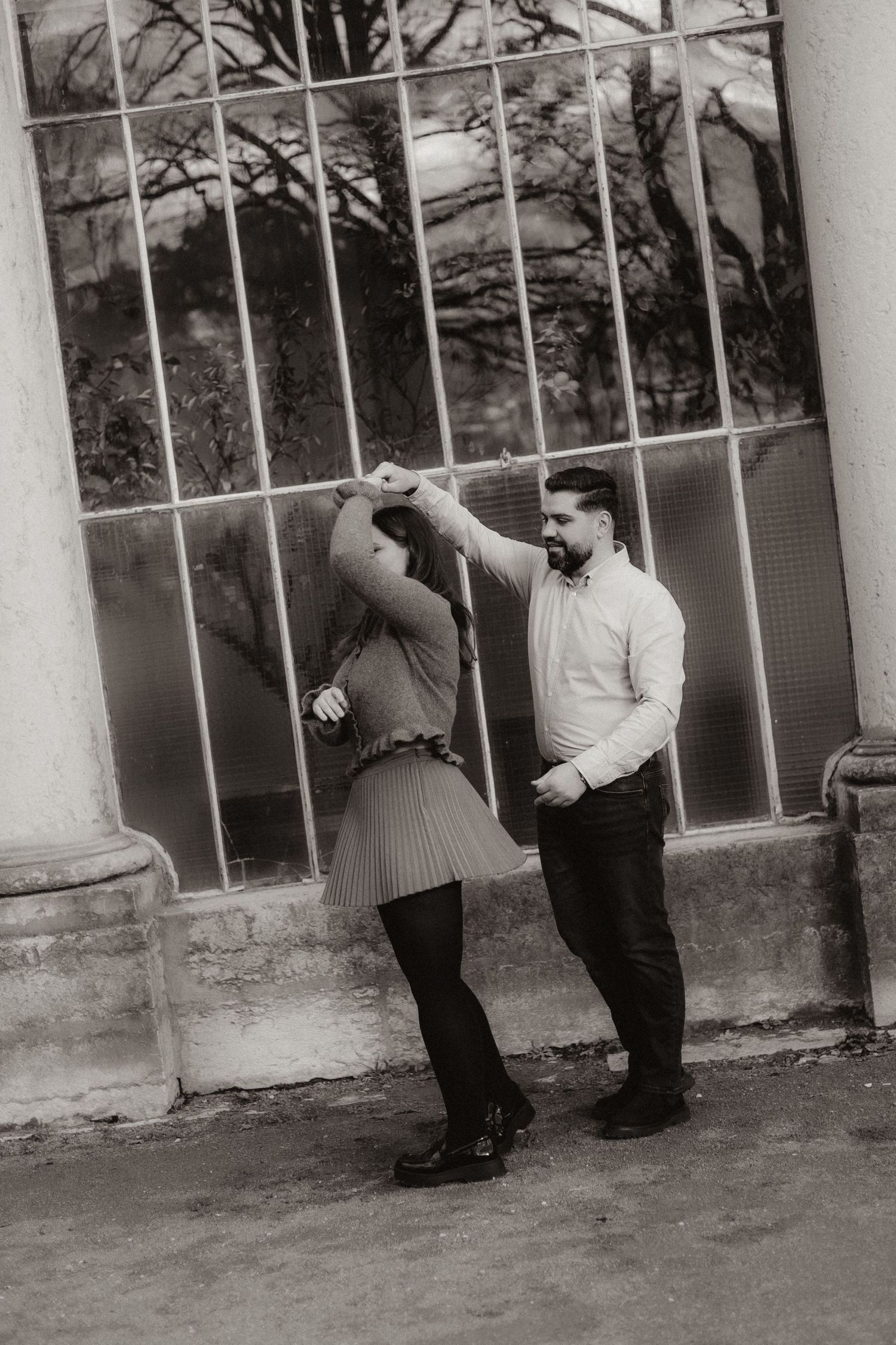 Black and white photo sequence showing romantic couple dancing playfully against an outdoor wall with columns.