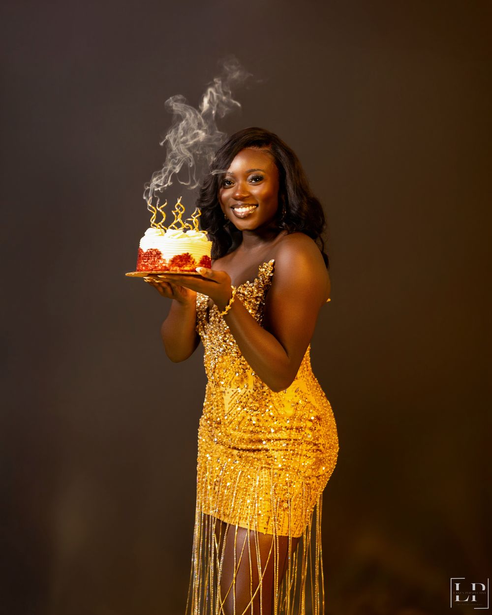 Glamorous portrait in gold sequined fringe dress with dramatic lighting and smoke effects.