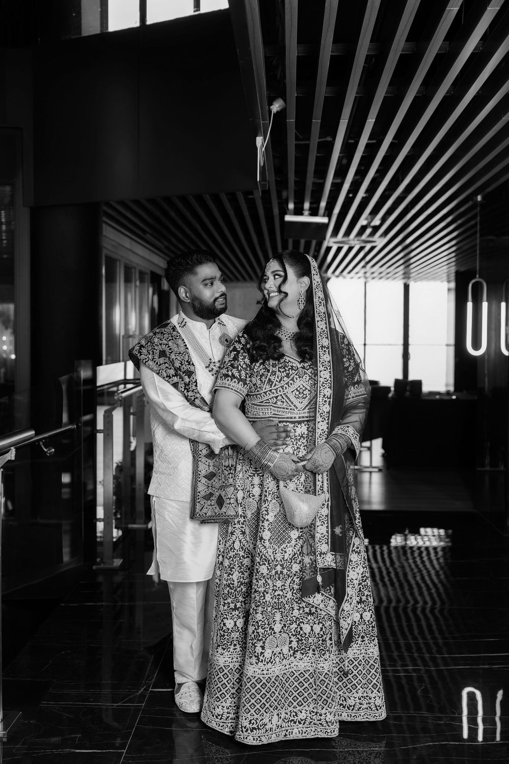 Black and white photos show a couple dancing together in a modern indoor venue with dramatic lighting and reflective floors.