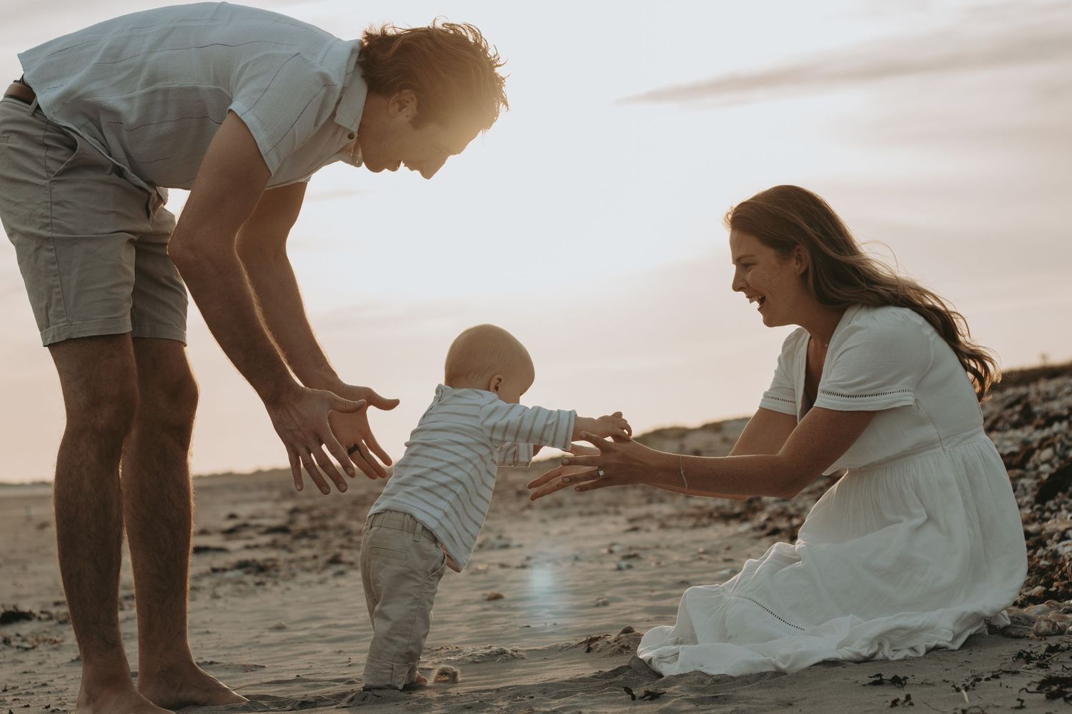 Family sharing joyful moments together in a golden field during sunset.