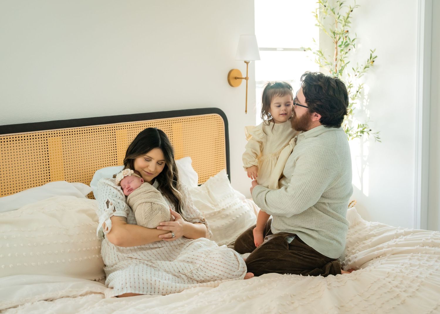 A series of romantic lifestyle photos showing a couple cuddling and embracing on a white bed in a sunlit room.