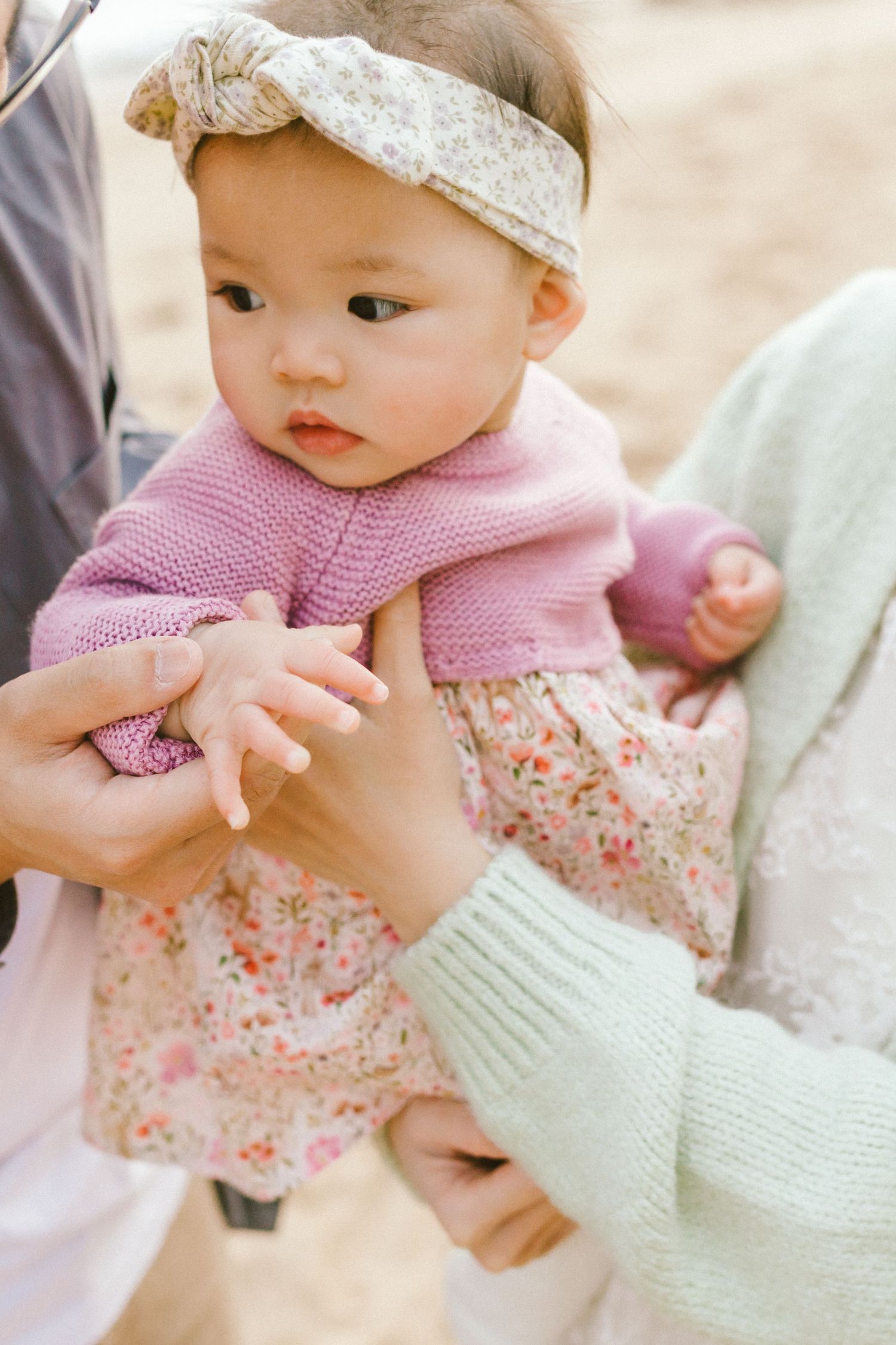 Close-up shots of an adorable baby wearing a pink outfit and lace headband.