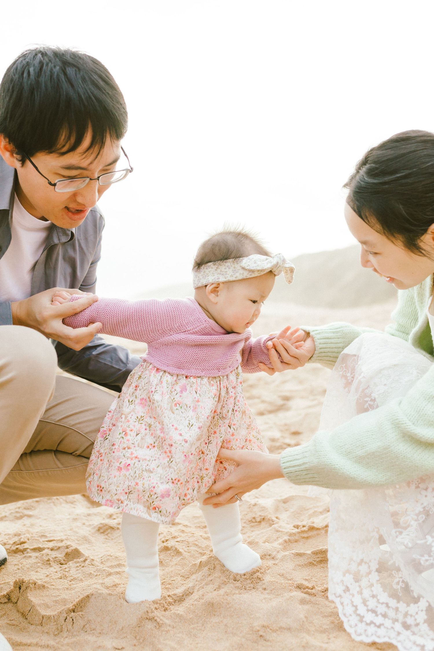 Two people sit on the floor together engaging in a playful activity with white powder or dough.
