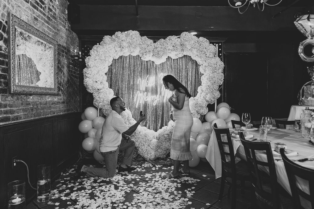 Black and white reception photos with elegant balloon and floral decorations.