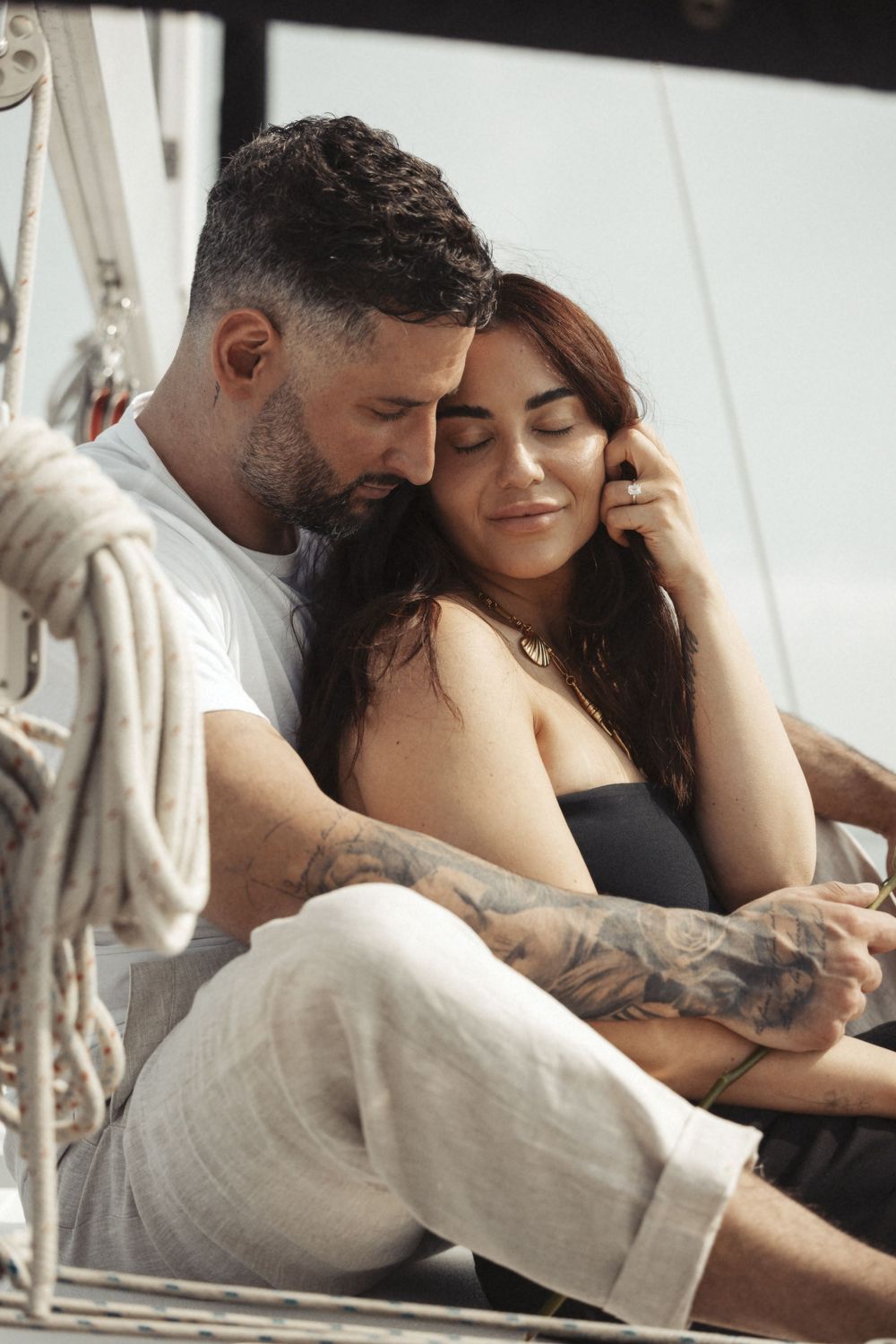 Romantic couple sharing tender moments on a sailboat.