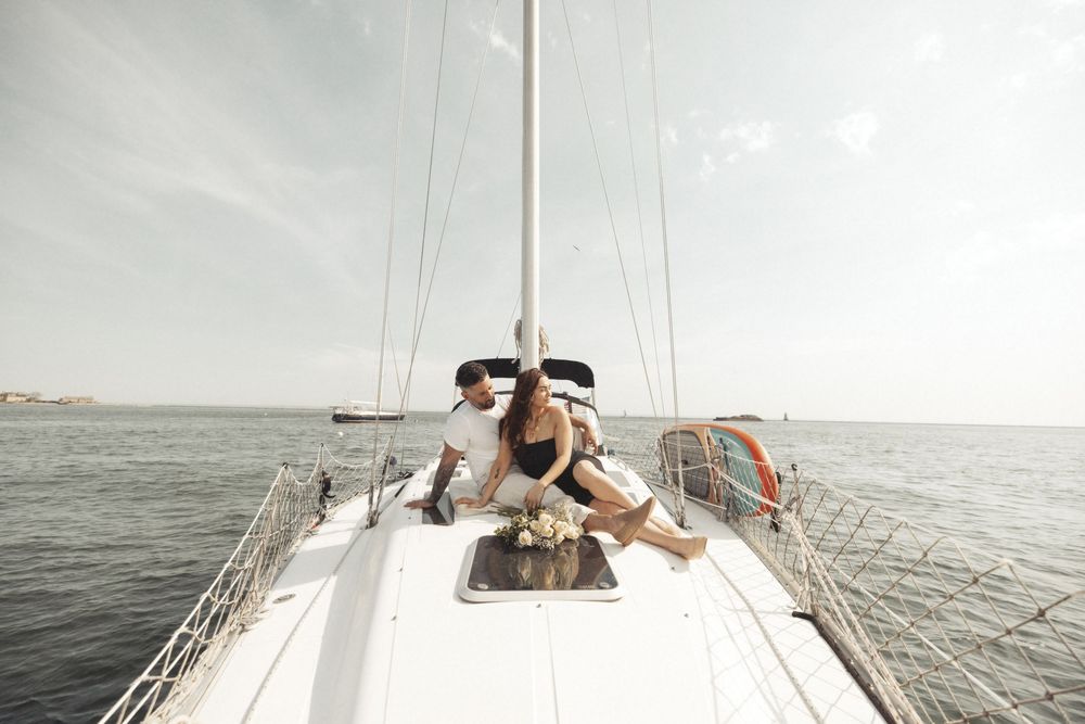 Dreamy sailing engagement photos captured during golden hour on the ocean.