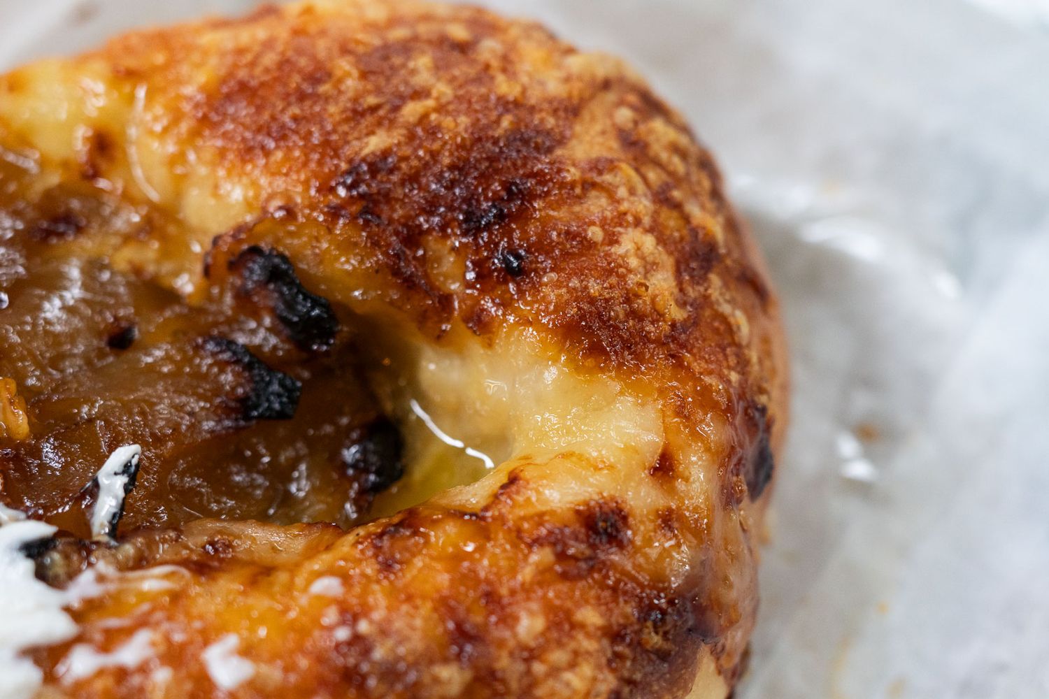 Close up of caramelized onion gruyere bagel.