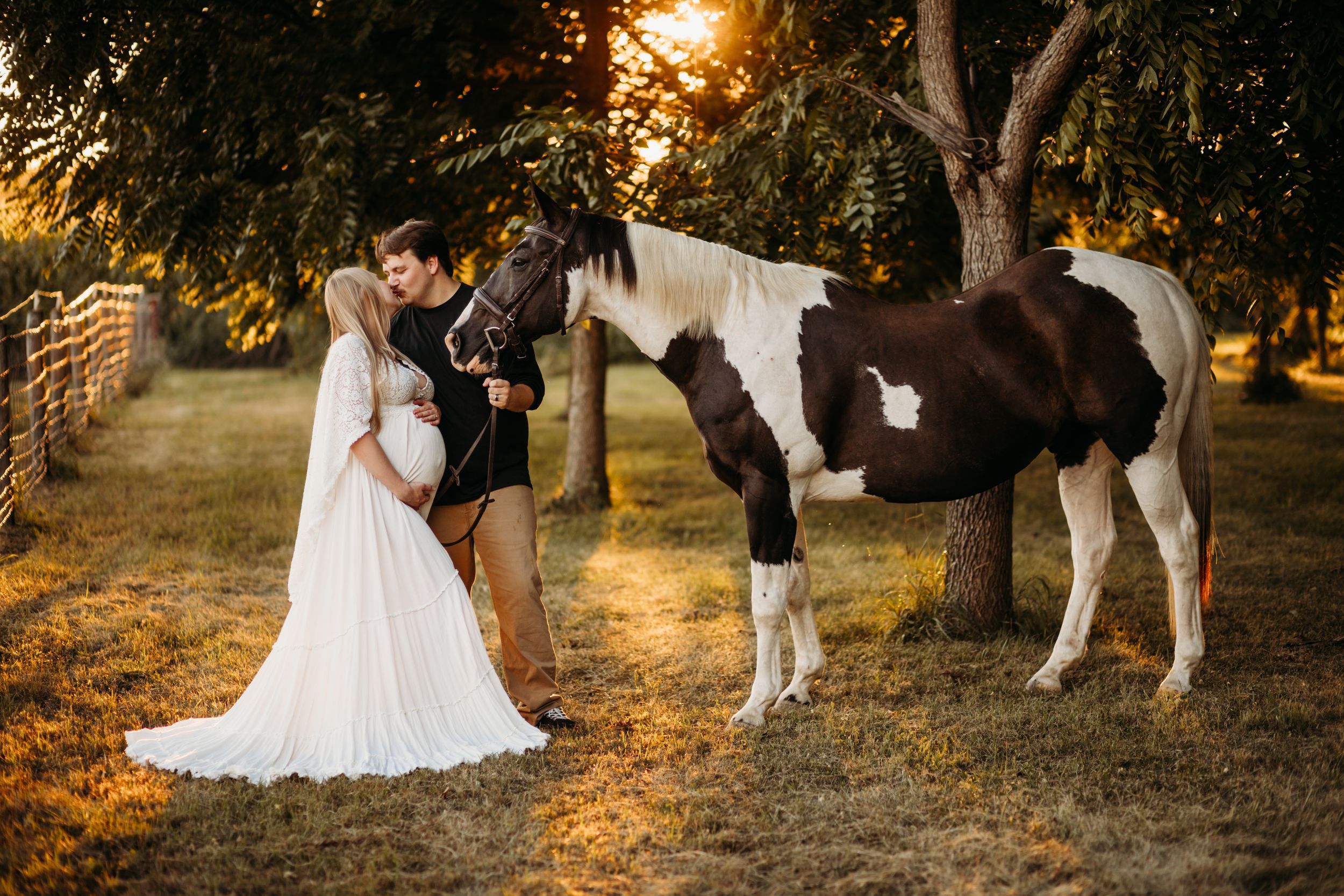 A romantic sunset wedding photoshoot with a majestic horse in a golden-lit field during golden hour.