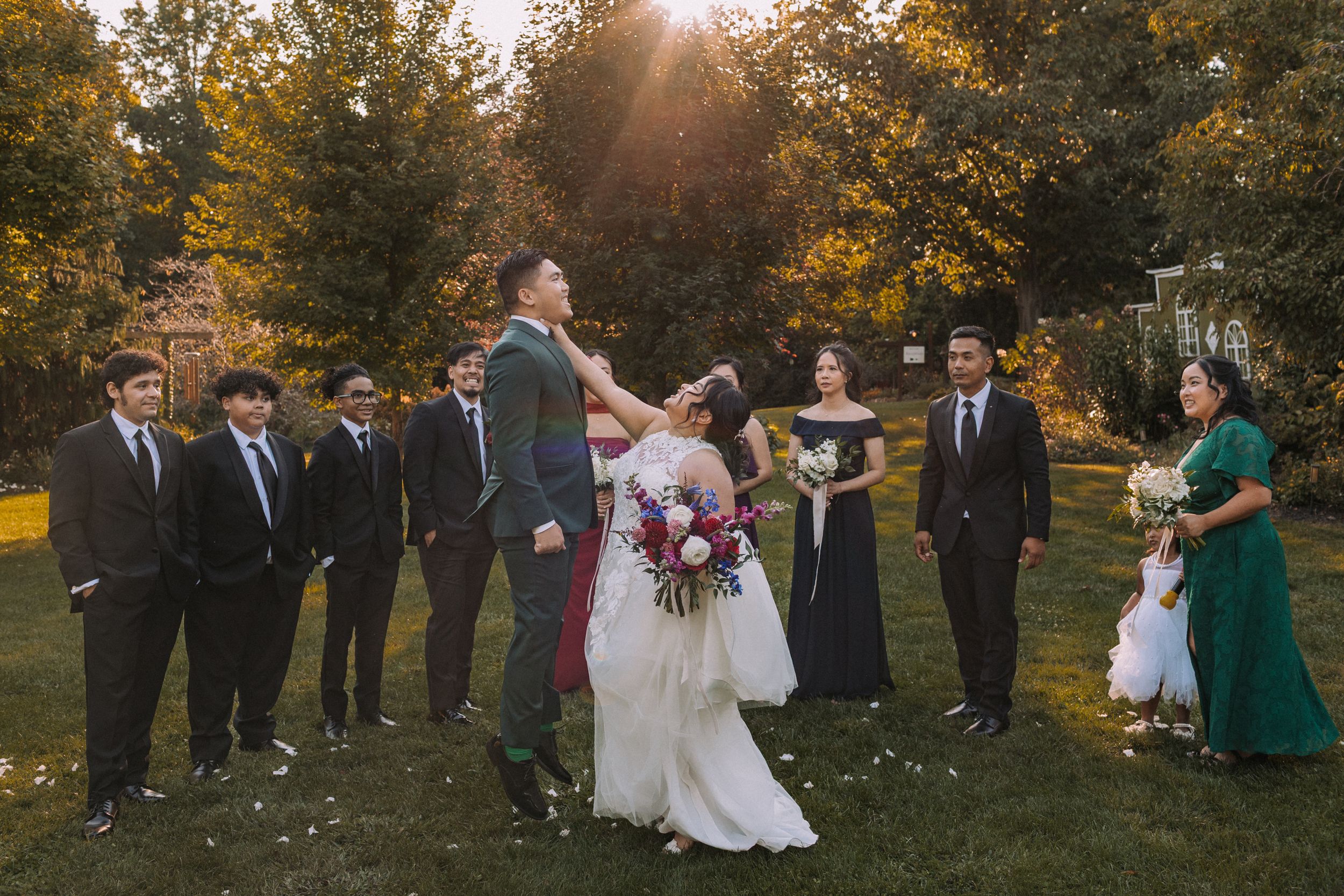 Wedding celebration in a park during fall with trees showing golden autumn colors.