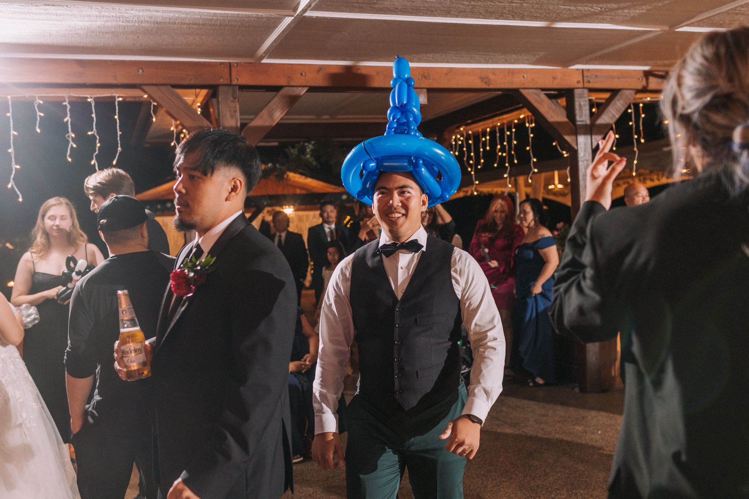 Indoor wedding reception with blue party decorations and string lights overhead.