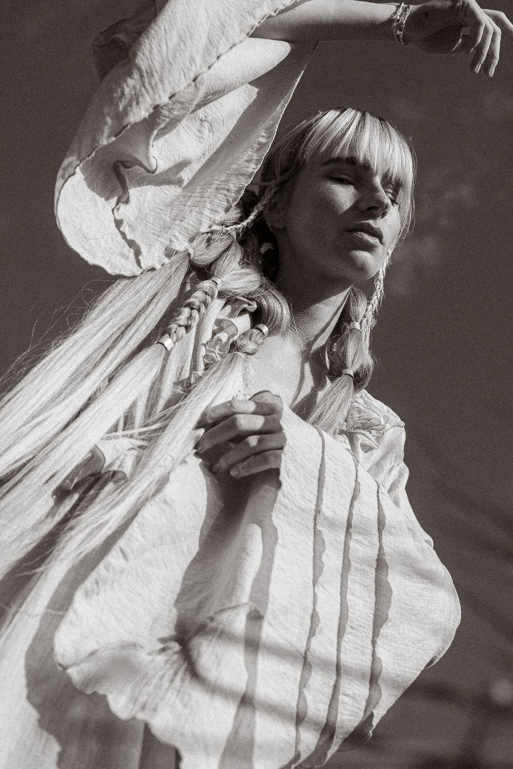 Black and white fashion portrait series showing ethereal poses in a white ruffled Victorian-style blouse against dark background.