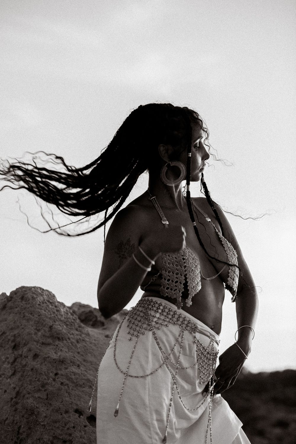 Black and white artistic photo series showing a figure with long flowing hair against a desert landscape in motion.