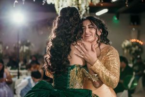 Two people share an emotional moment during a celebration with festive lighting.