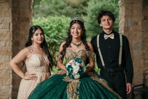 Celebratory group photo under stone archway with emerald green formal attire.