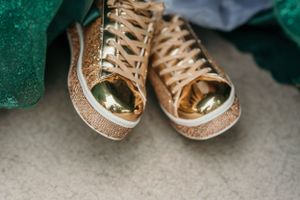 Gold glitter high-top sneakers add a modern twist to formal attire.
