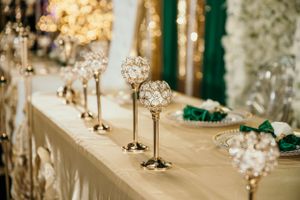 Crystal centerpiece decorations on an elegant reception table with gold accents.