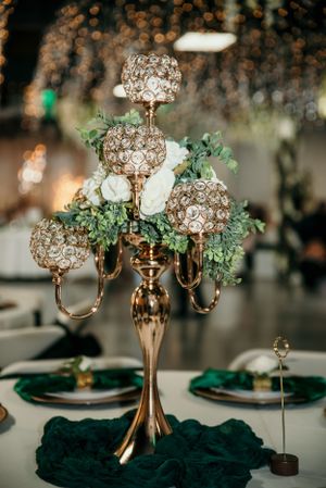 Crystal candelabra centerpiece with gold accents and emerald green table decor.