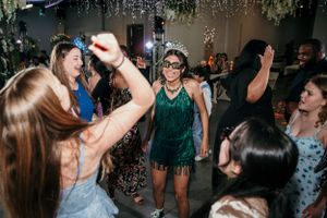 Dancing party guests enjoy a celebration with sparkling decorations and a green dress theme.