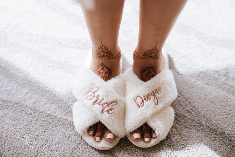 White bridal slippers with bows arranged in a stylish progression on a light colored surface.