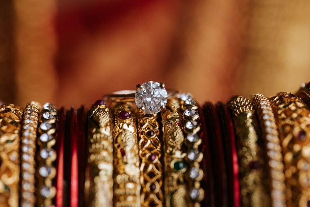 Rows of sparkling jewelry and necklaces displayed on wooden hangers with warm lighting in a retail store.