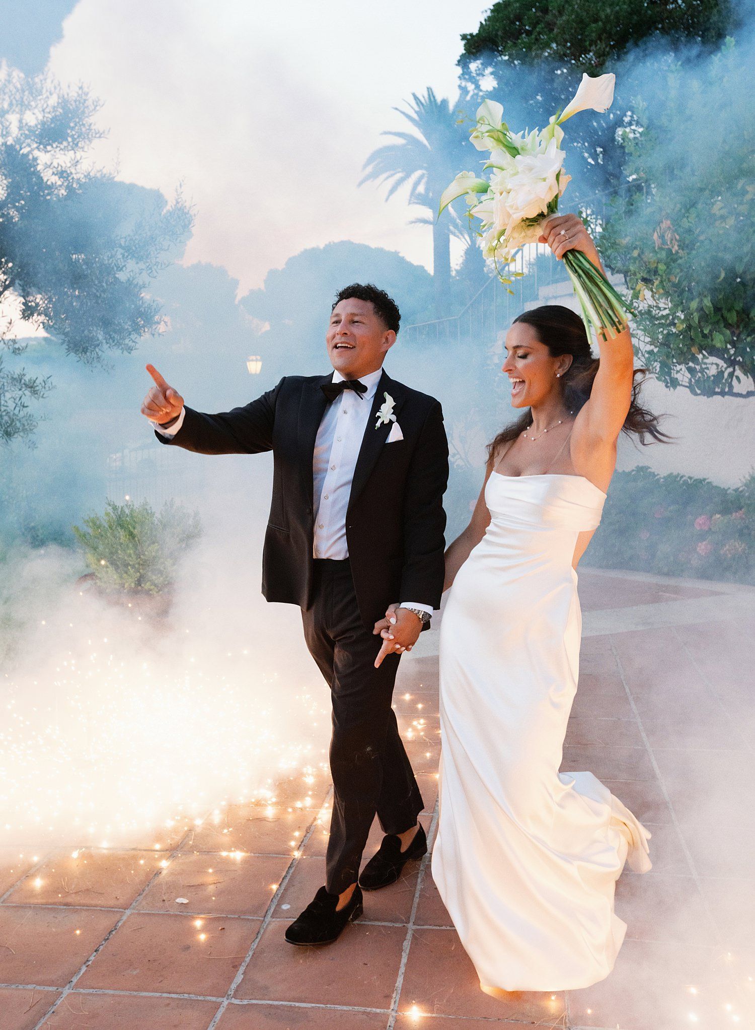 Couple dancing on a terrace with sparklers creating a magical effect during their wedding celebration.