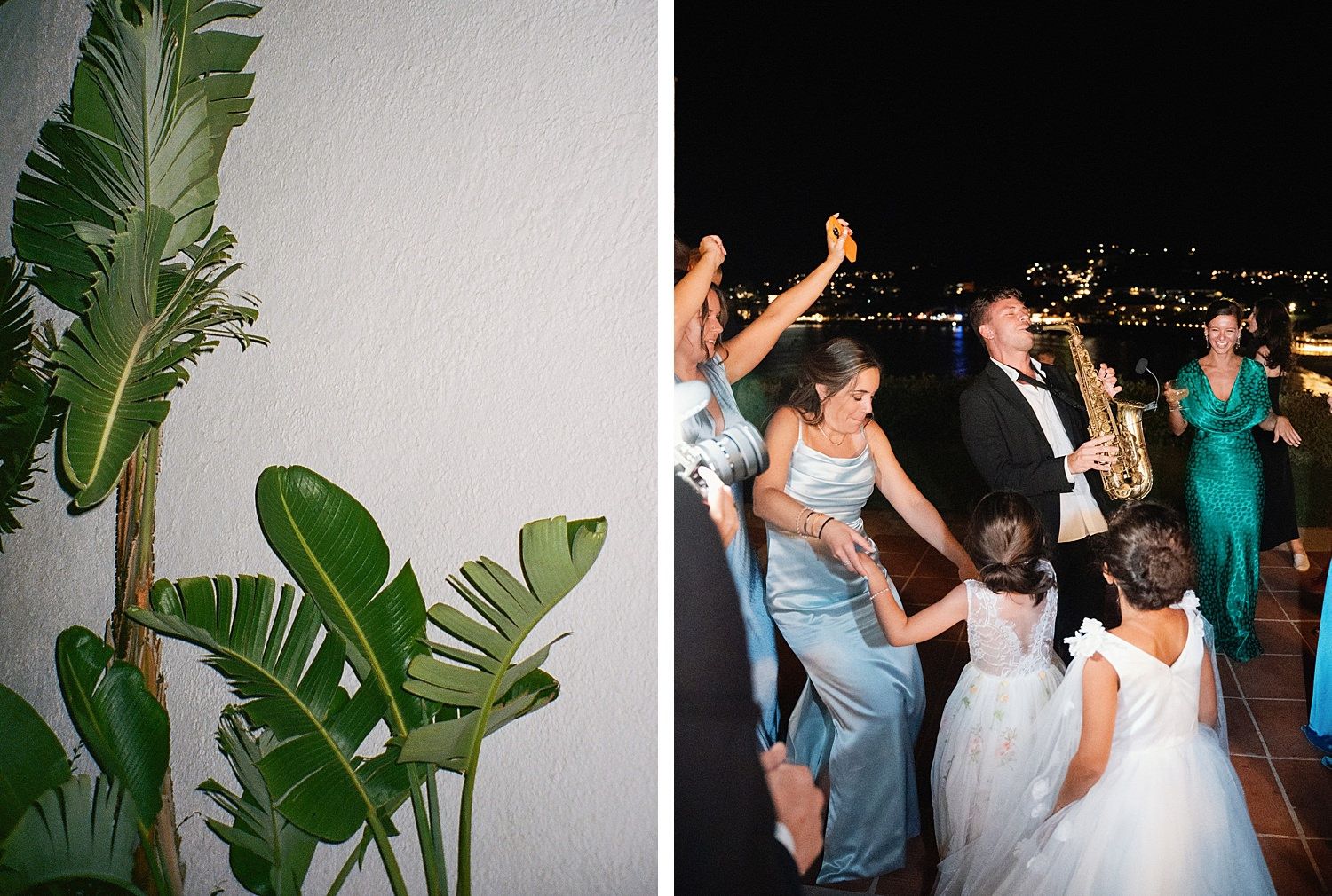 Wedding guests dancing and celebrating on a dimly lit dance floor with tropical plants visible in the background.