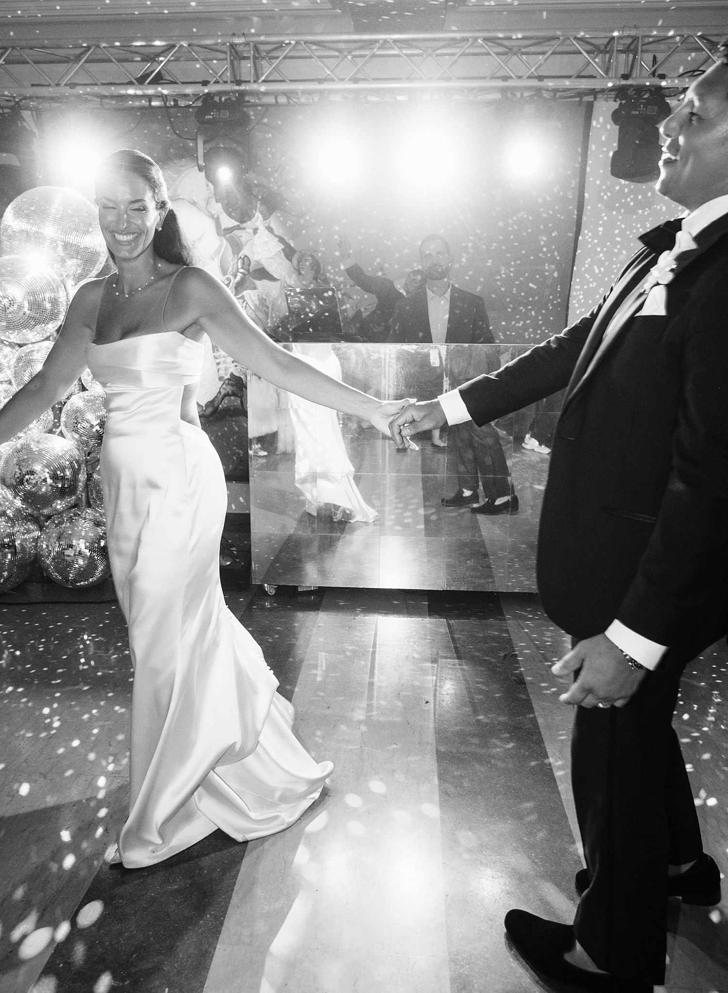 A series of black and white wedding dance photos showing couples twirling on a spotlit dance floor during a reception.