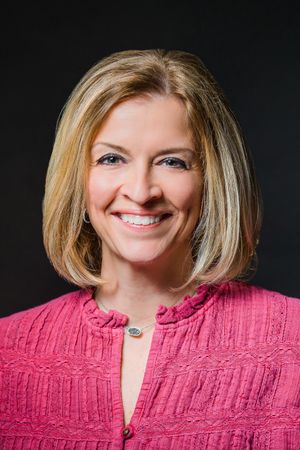Portrait series showing warm smiles while wearing a textured pink sweater against black backdrop.