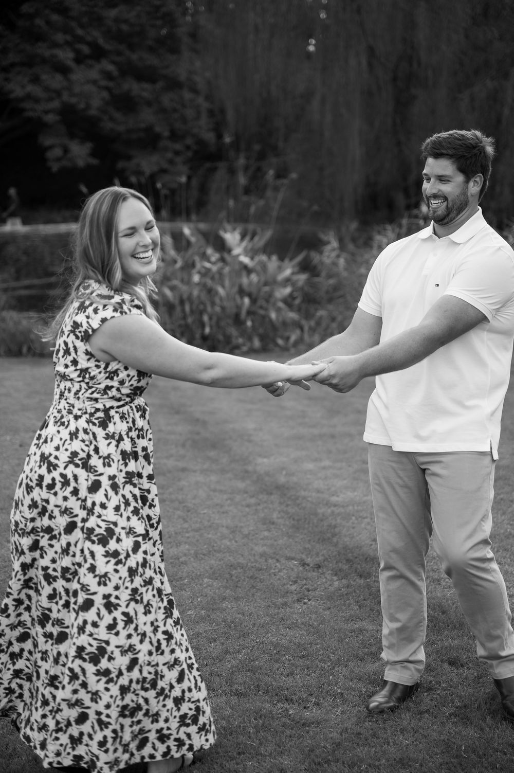 Black and white sequence of couple dancing and twirling on grass.