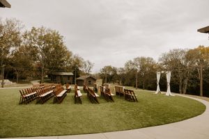 Panoramic view of wooden chairs arranged on a grassy hillside under an overcast sky.