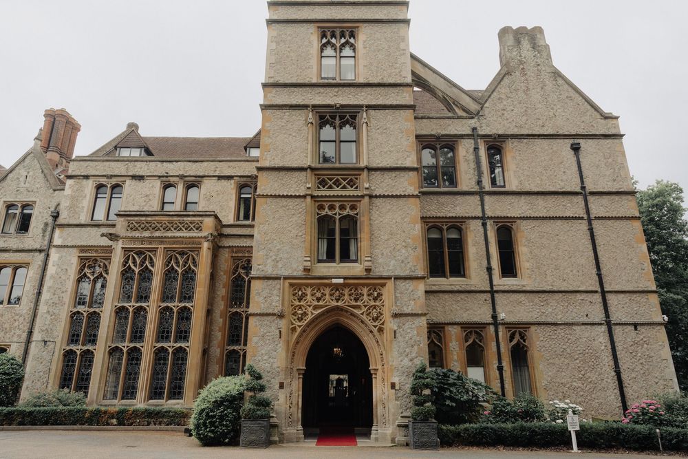 Panoramic view of a grand Gothic-style stone building with arched windows and ornate architecture.