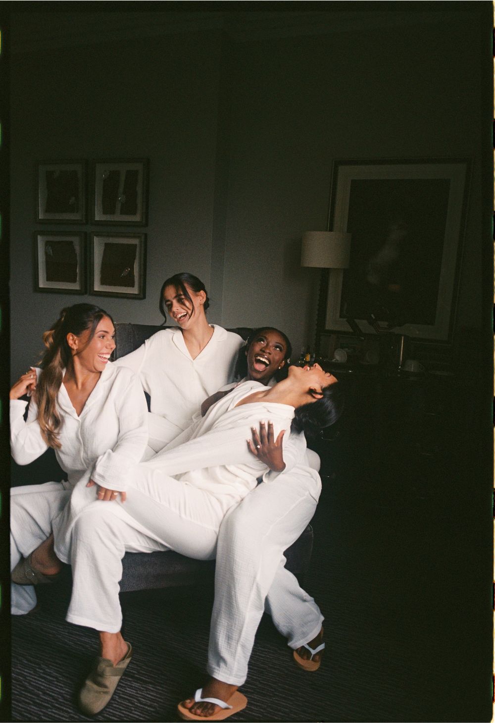 Group of people in white robes dancing and having fun in a dimly lit room.