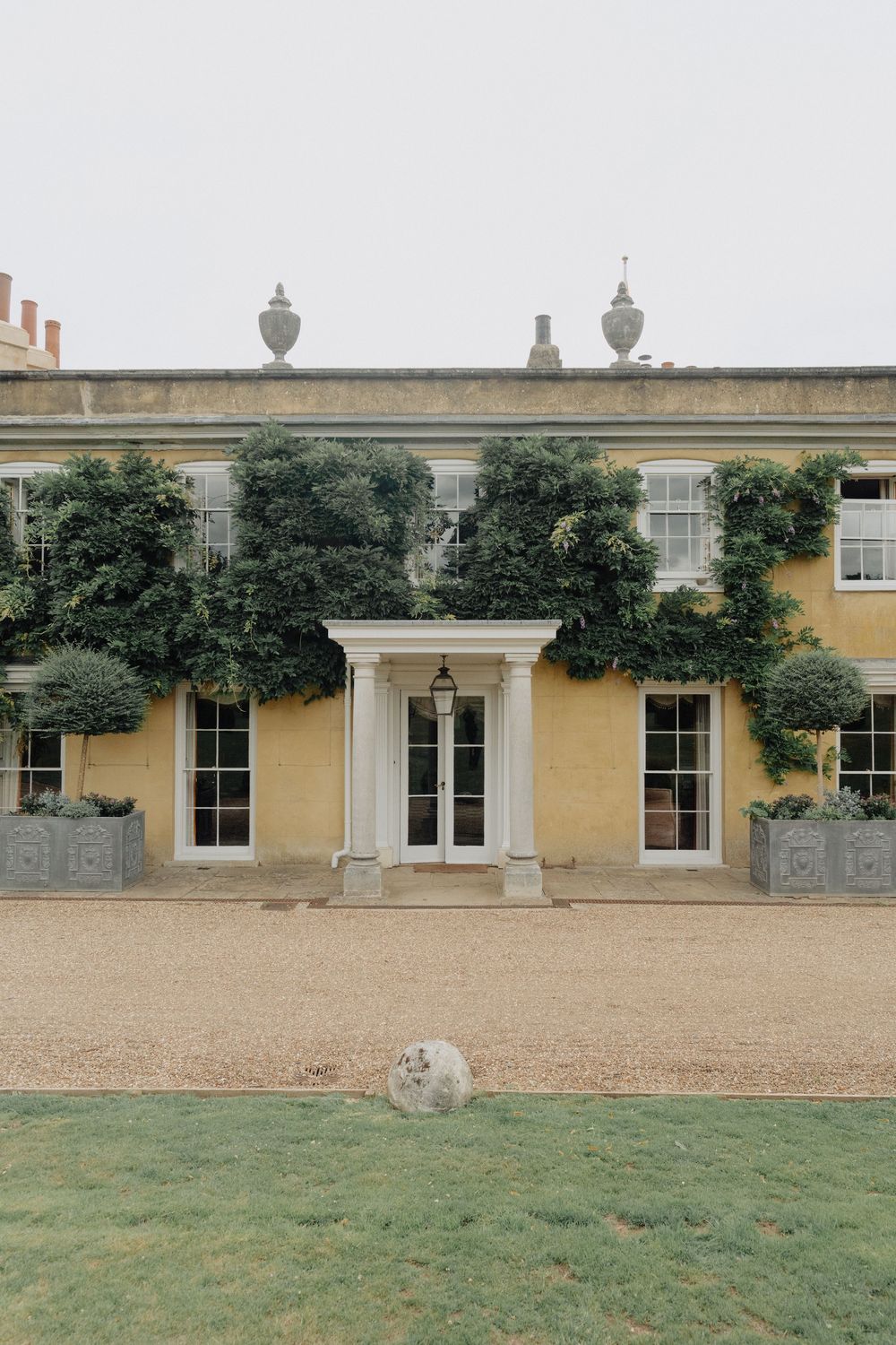 Elegant yellow stone manor house with classic Georgian windows and architectural details.